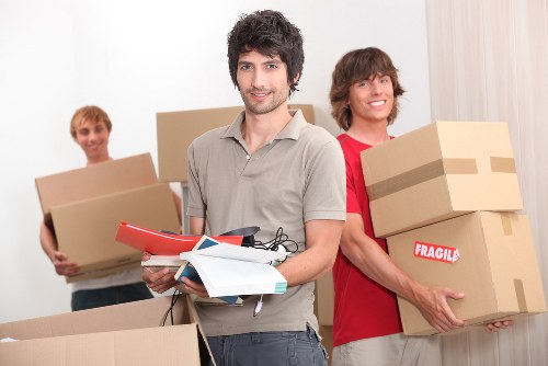 A moving team planning flat removals in Hampton with boxes and furniture in a hallway